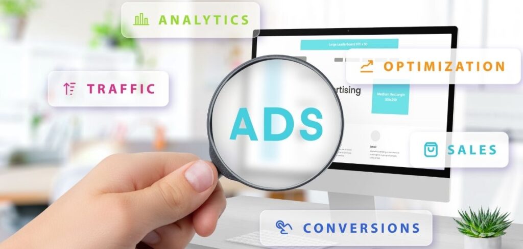 Hand holding a magnifying glass over the word ADs on a computer screen, surrounded by labels for analytics, traffic, optimization, sales, and conversions to illustrate digital advertising performance
